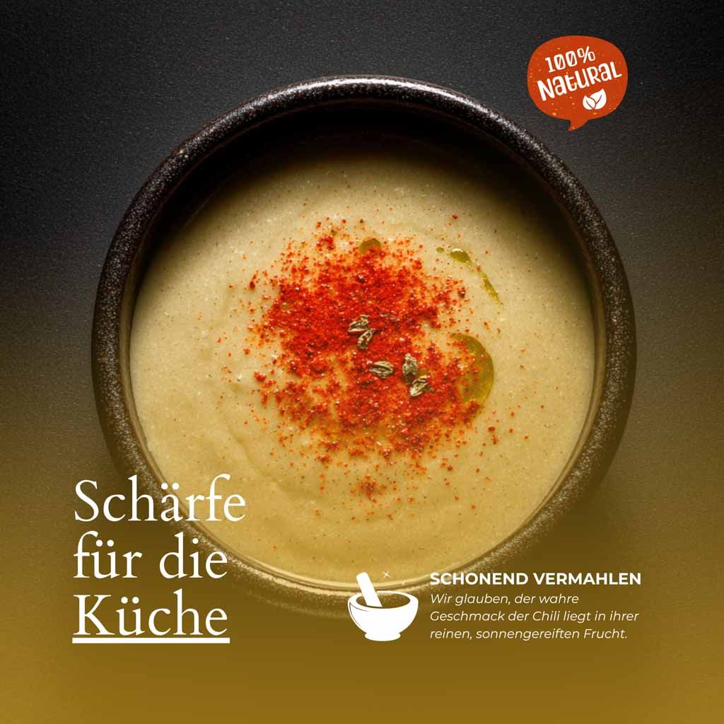 Suppe mit Chili-Pulver. Aufschrift: Schärfe für die Küche. Text: Schonend vermahlen. Siegel: 100% Natural.