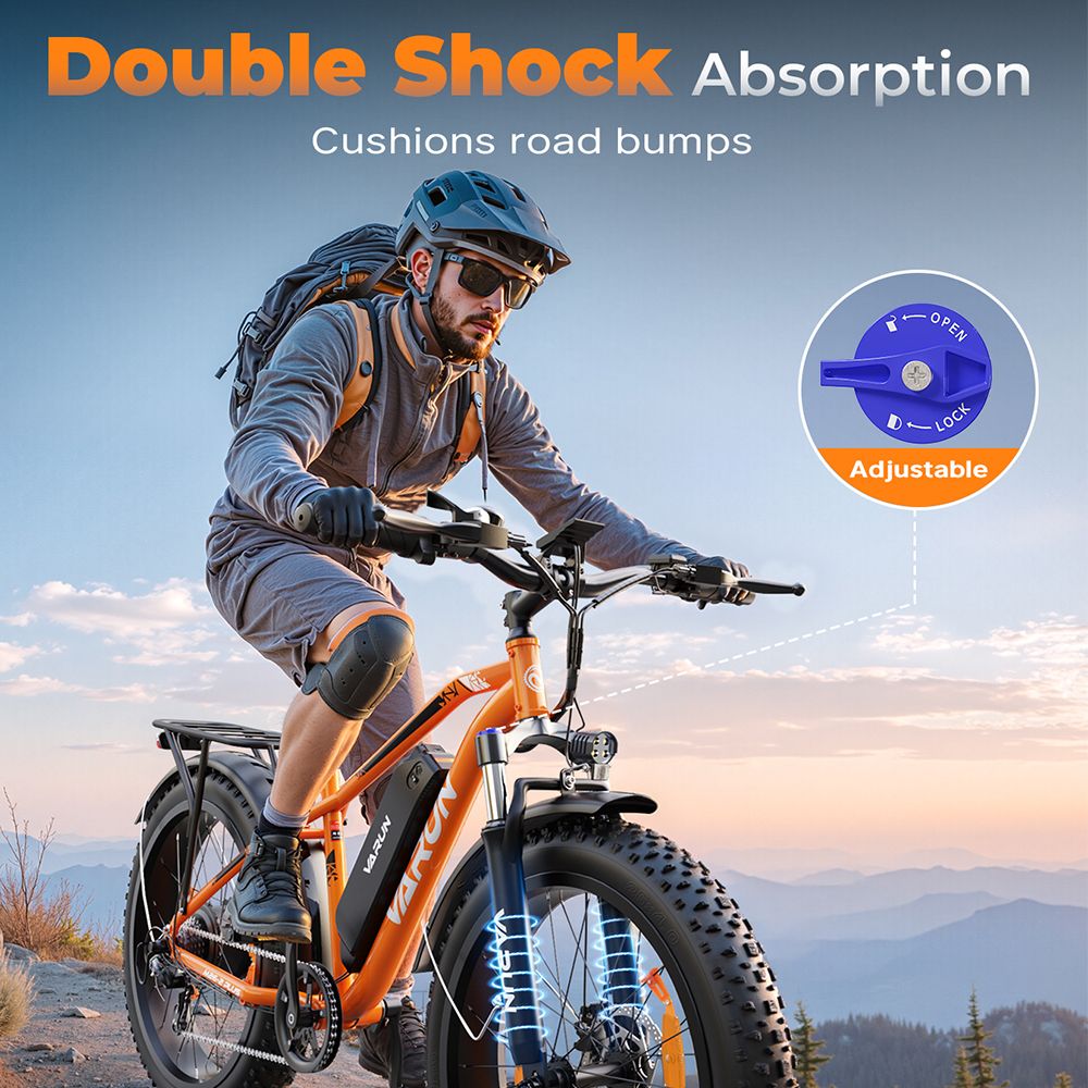 Person fährt auf einem orangefarbenen VARUN E-Mountainbike. Doppelte Stoßdämpfung. Verstellbare Federung.