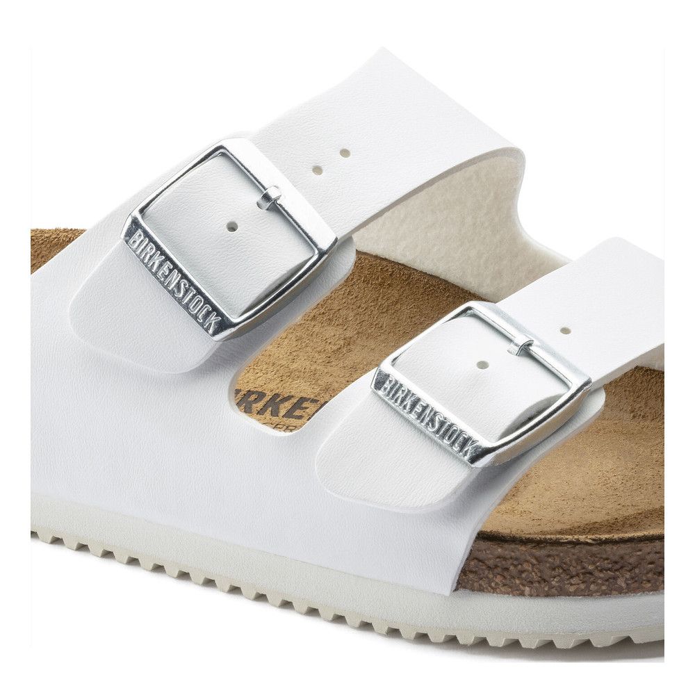 Nahaufnahme einer weißen Sandale mit zwei Riemen. Birkenstock-Logo auf den Schnallen.