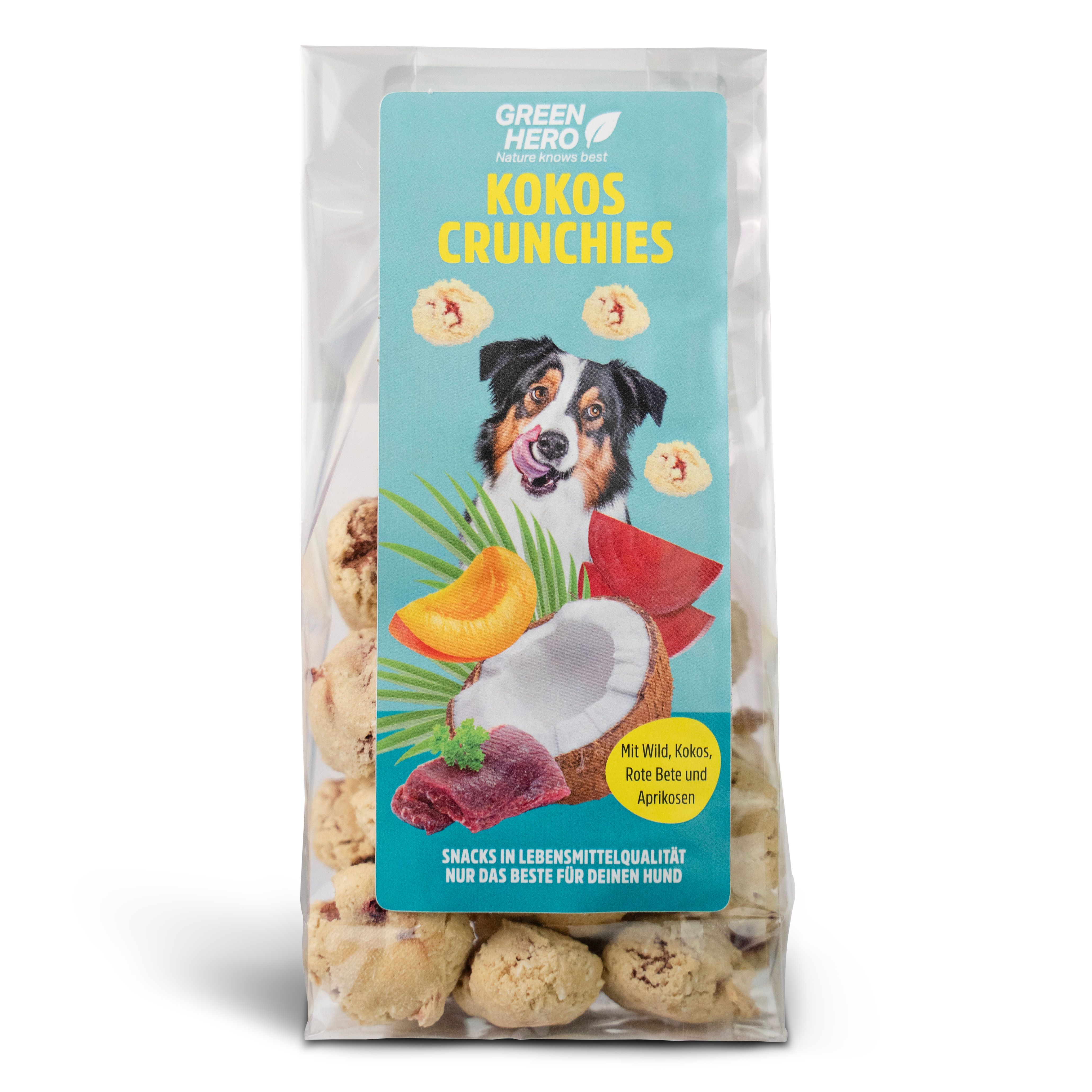 Transparente Tüte mit Kokos Crunchies für Hunde. Aufdruck mit Produktname, Hund, Kokosnuss, Aprikose und Text. "Snacks in Lebensmittelqualität".