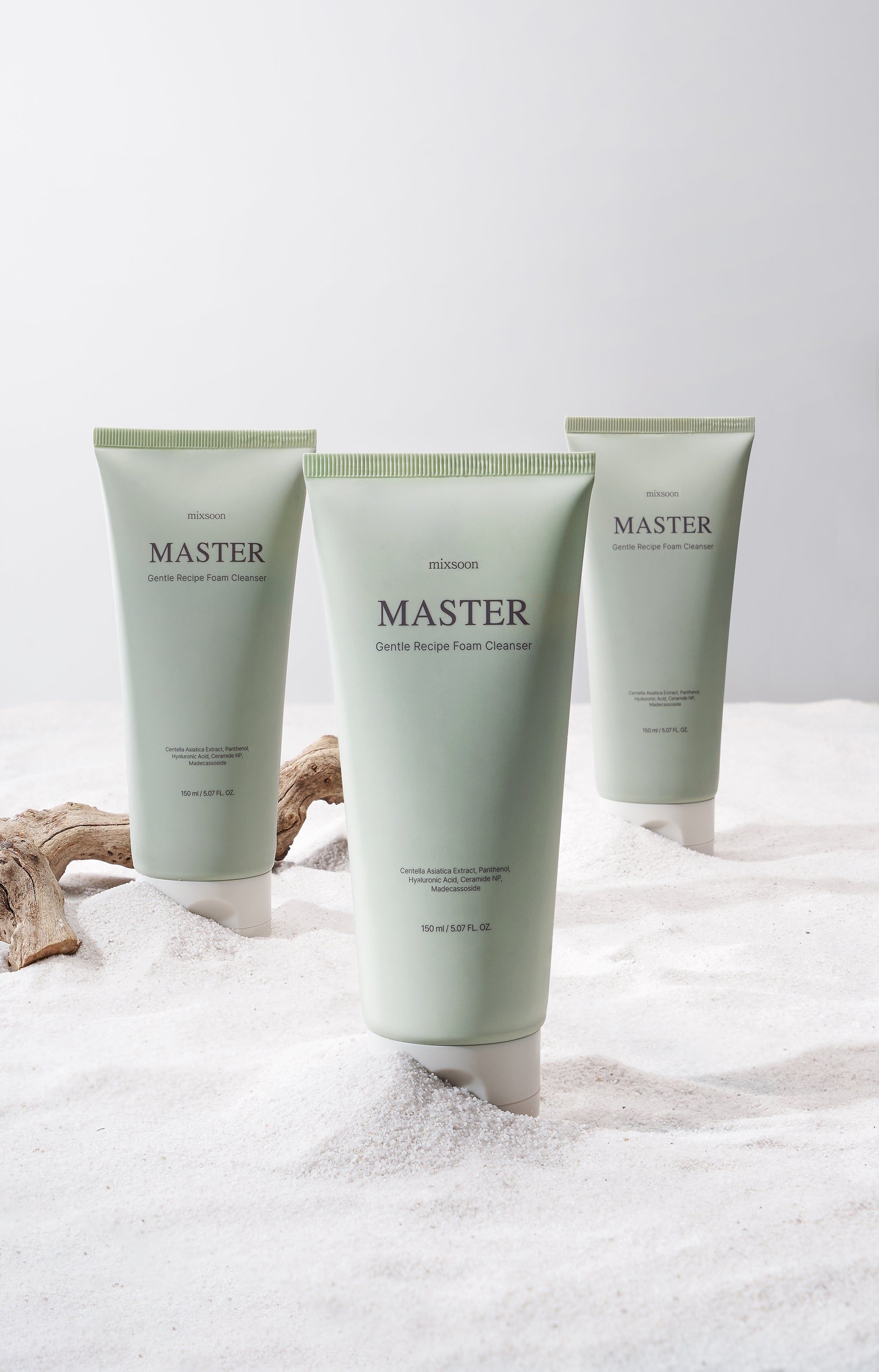 Drei grüne Tuben mit weißem Deckel. Aufschrift: mixsoon Master Gentle Recipe Foam Cleanser. Auf Sand platziert.