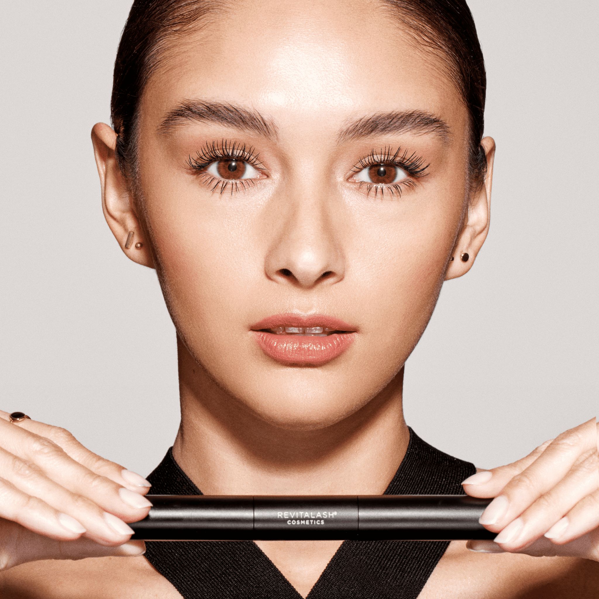 Nahaufnahme einer Frau, die das RevitaLash® Cosmetics Double-Ended Volume Set hält.