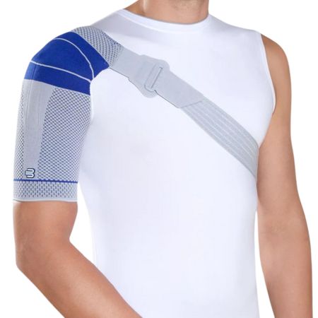 Person mit OmoTrain S Schulterbandage. Blau-graue Bandage, grauer Riemen, weißes Shirt.