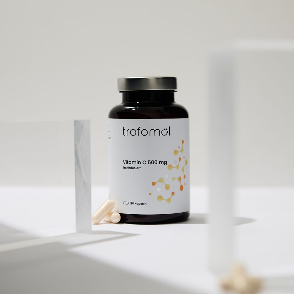 Braune Flasche mit silbernem Deckel, daneben Kapseln. Etikett mit "trofomol", "Vitamin C 500 mg", "120 Kapseln".
