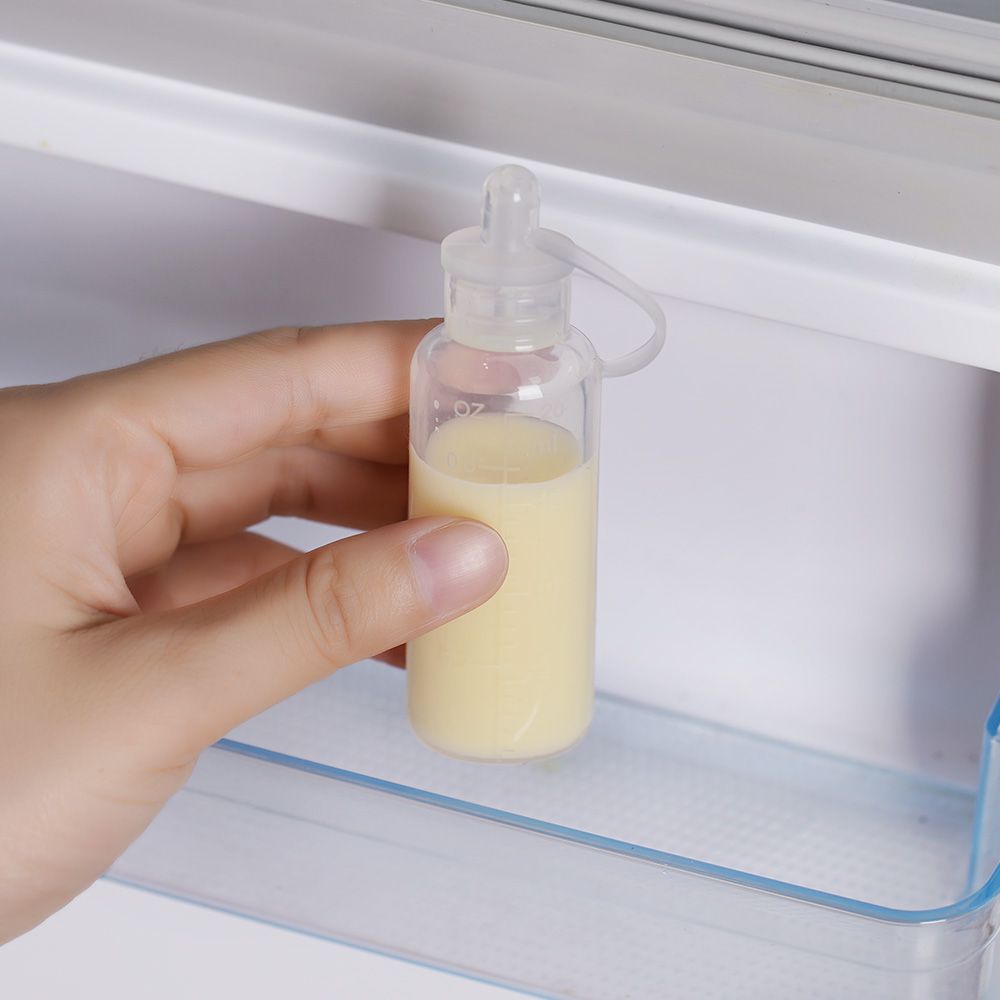 Eine Hand greift nach einem transparenten Behälter mit gelblicher Flüssigkeit in einem Kühlschrank.