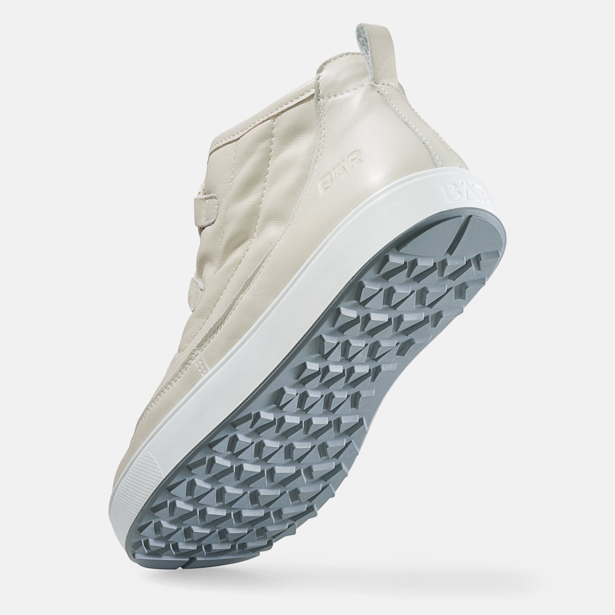 Beige Stiefelette von unten. Graue Sohle mit Profil. Weißer Rand. Logo auf der Seite.