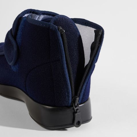 Nahaufnahme des Reißverschlusses an der Rückseite eines schwarzen Hausschuhs.