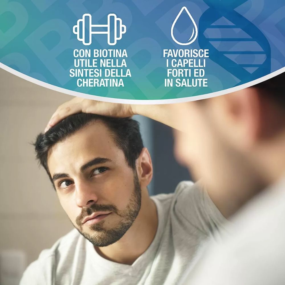 Uomo si guarda allo specchio. Testo: Con biotina utile nella sintesi della cheratina.