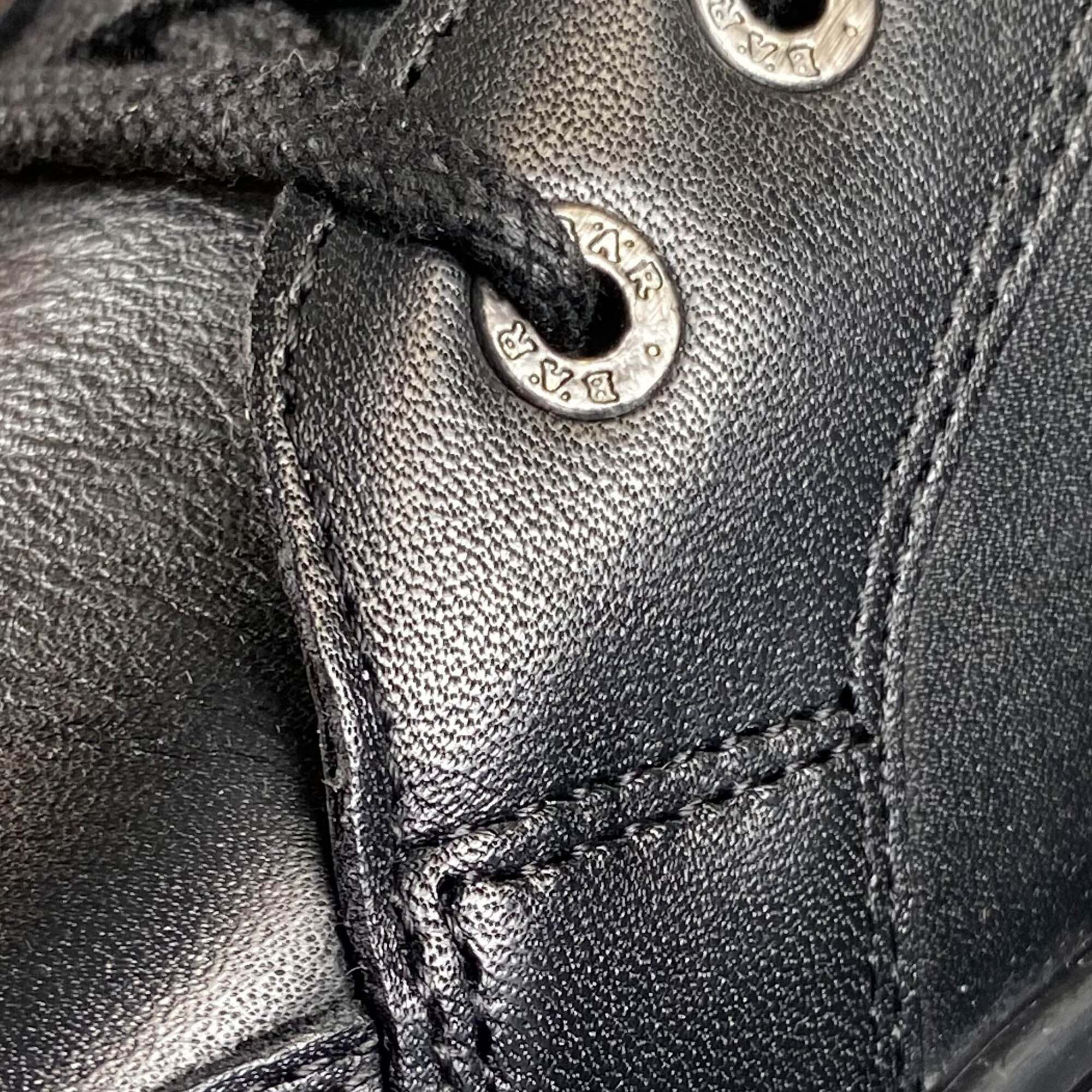 Nahaufnahme schwarzer Lederstiefel-Schnürsenkel und Ösen mit sichtbarem Logo.