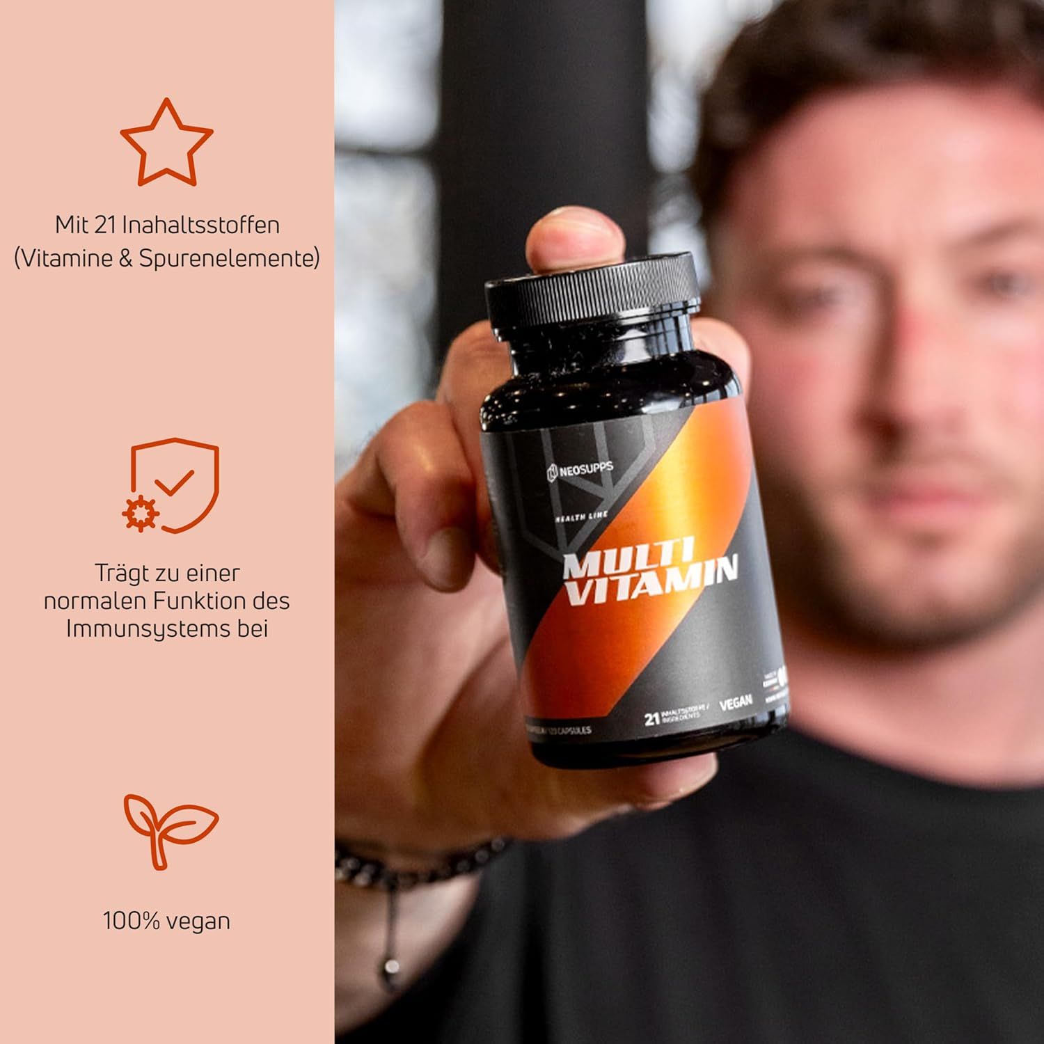 Schwarze Flasche mit "Multi Vitamin"-Etikett. Enthält 21 Inhaltsstoffe, vegan. Person hält die Flasche.