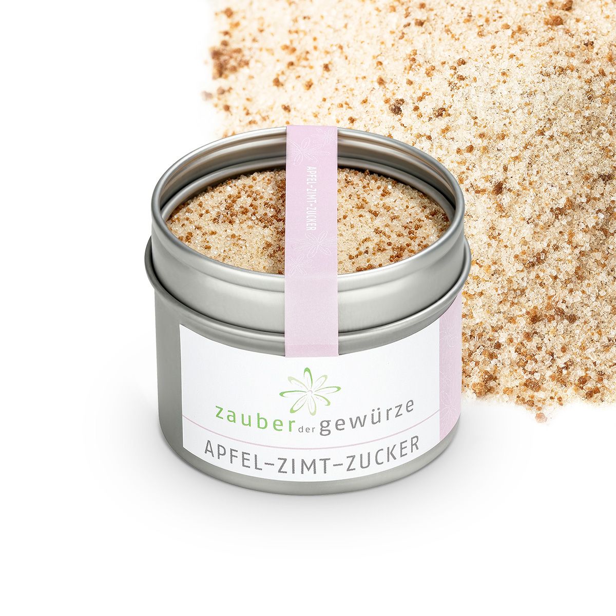 Geöffnete Dose Apfel-Zimt-Zucker. Rosa Etikett mit Produktnamen und Logo. Streuung von Zucker daneben. Rosa Band am Deckel.