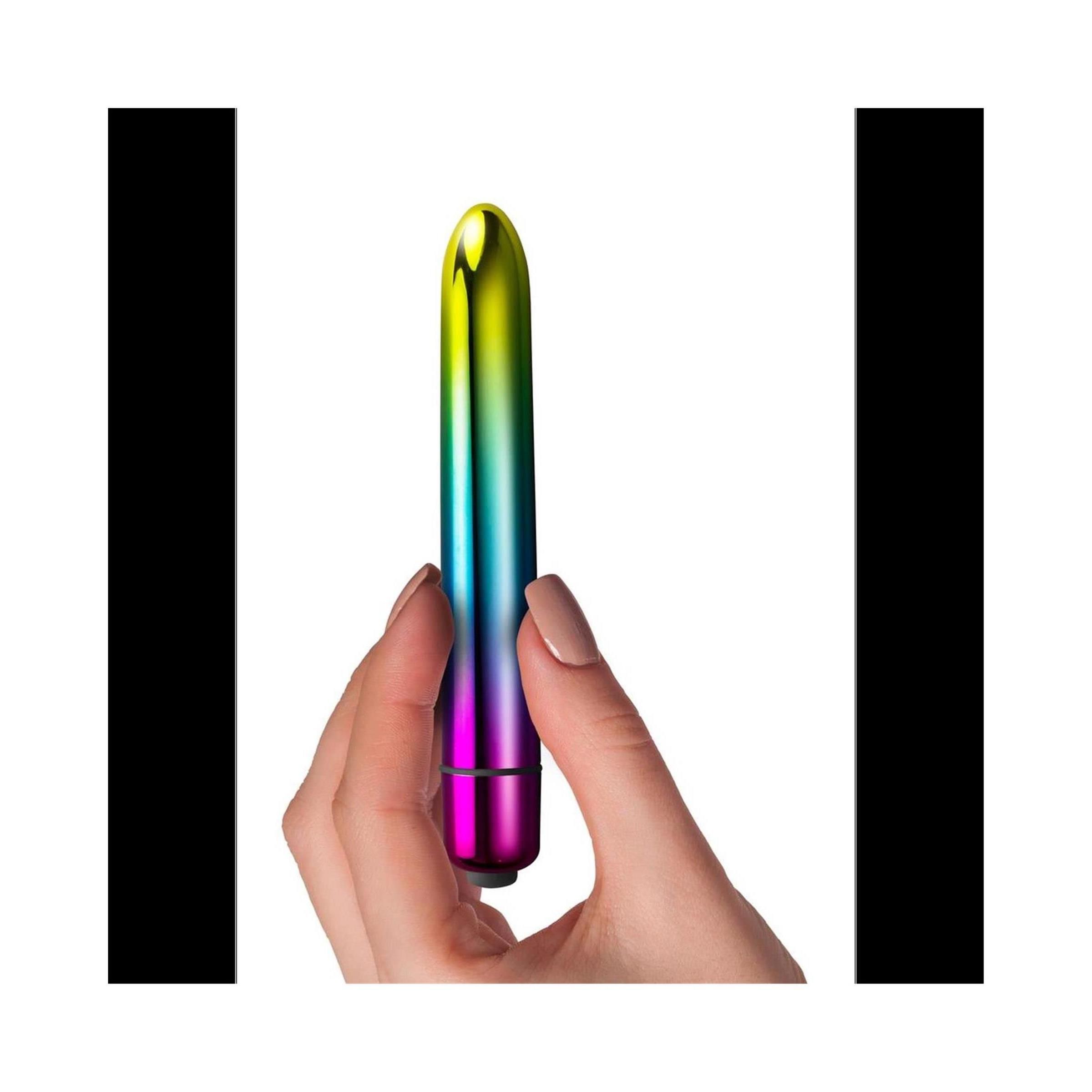 Hand hält einen zylindrischen Vibrator in Regenbogenfarben. Sichtbare Form und Farbe.