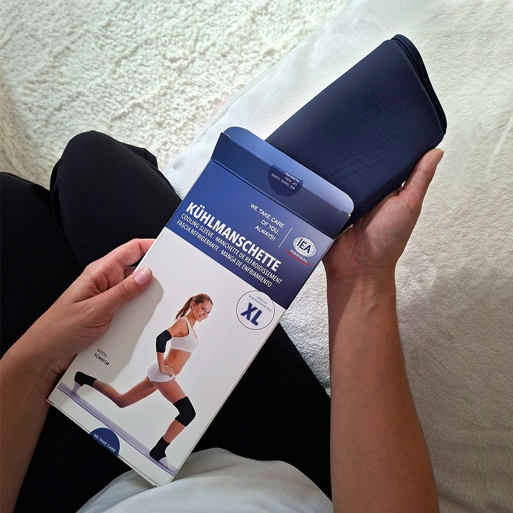 Person hält Kühlmanschette und Verpackung. Verpackung mit Text: Kühlmanschette XL.