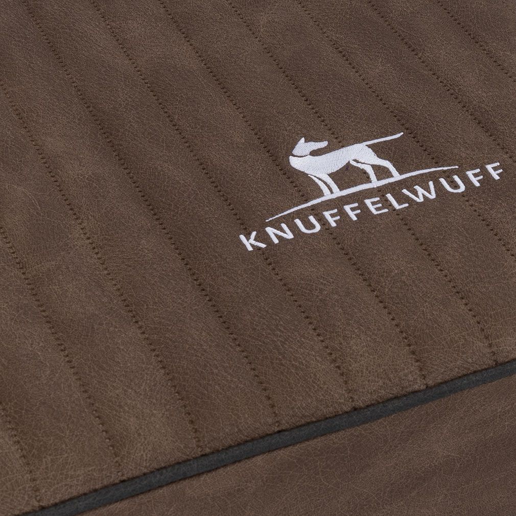 Detailansicht der orthopädischen Hundematte Palomino. Braunes Material mit Steppung. Knuffelwuff-Logo.