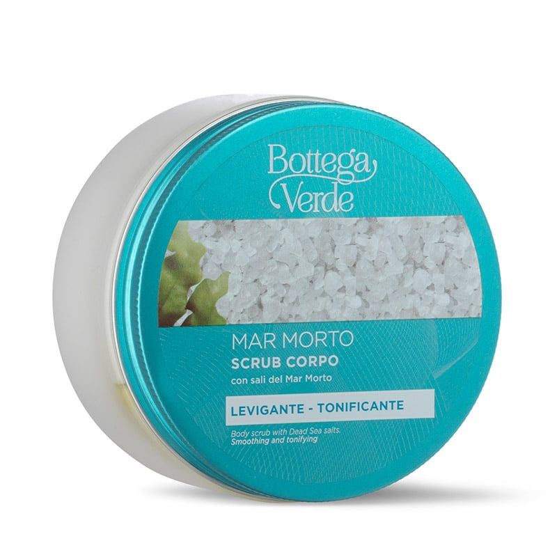 Un contenitore rotondo di Bottega Verde con il prodotto "Mar Morto Scrub Corpo". Il coperchio turchese presenta testo bianco e un'immagine di sale. Il contenitore bianco contiene uno scrub corpo con sali del Mar Morto.