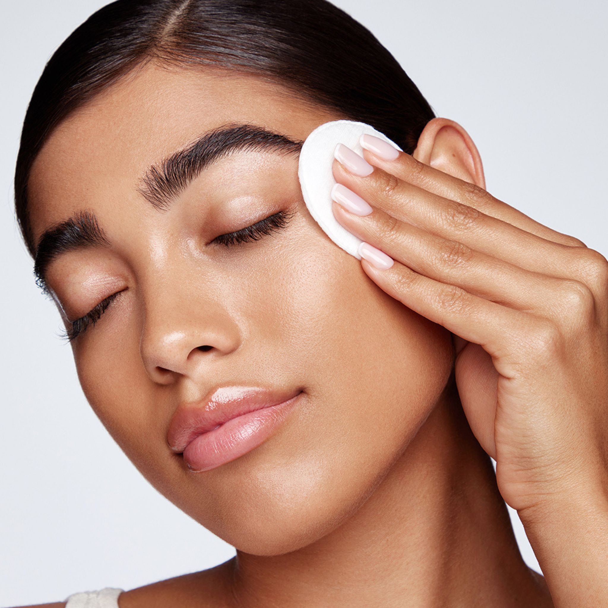 Nahaufnahme einer Person, die ein Wattepad am Auge verwendet. Hautpflege-Kontext.