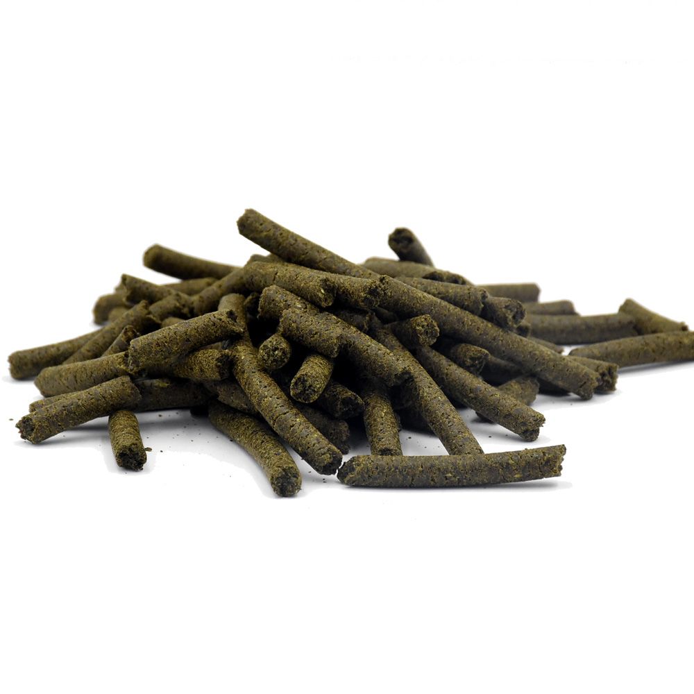 Haufen zylindrischer, dunkelgrüner Pellets. Einzelne Pellets liegen verstreut.
