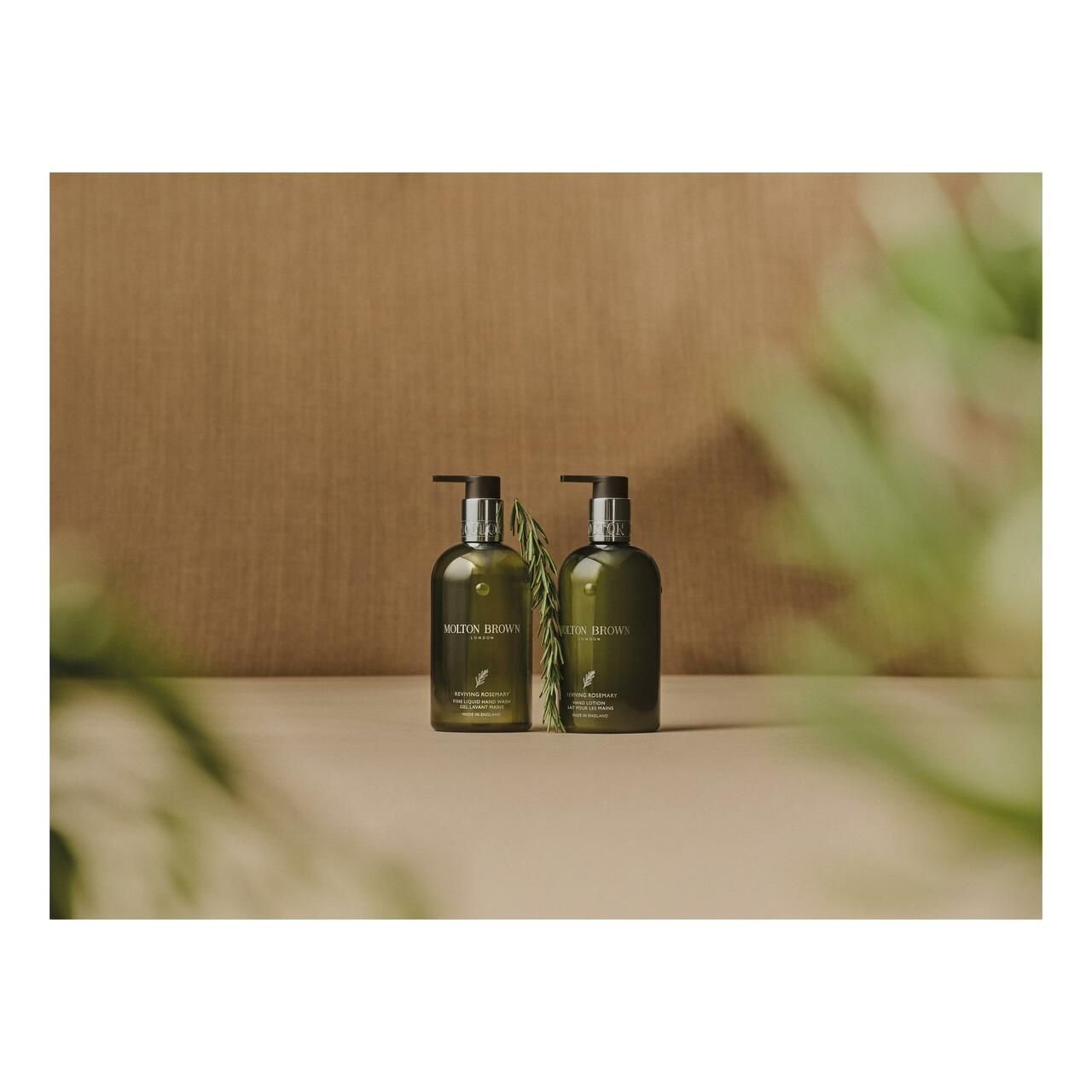 Zwei grüne Flaschen mit Pumpen. Aufschrift: Molton Brown. Hintergrund: beige und grüne Blätter.