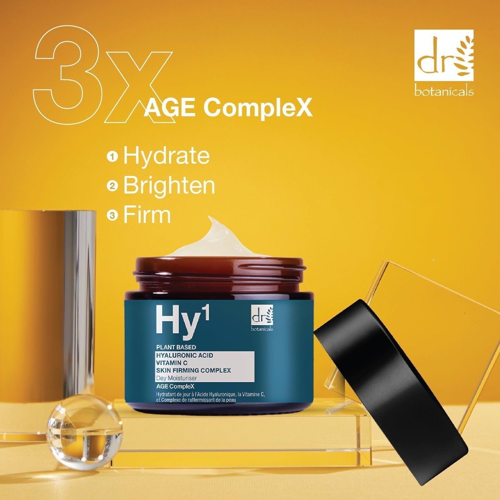 Tiegel mit schwarzem Deckel, Creme und Zubehör. Aufschrift: Hy1, Dr Botanicals, Hyaluronsäure, Vitamin C, Skin Firming Complex.