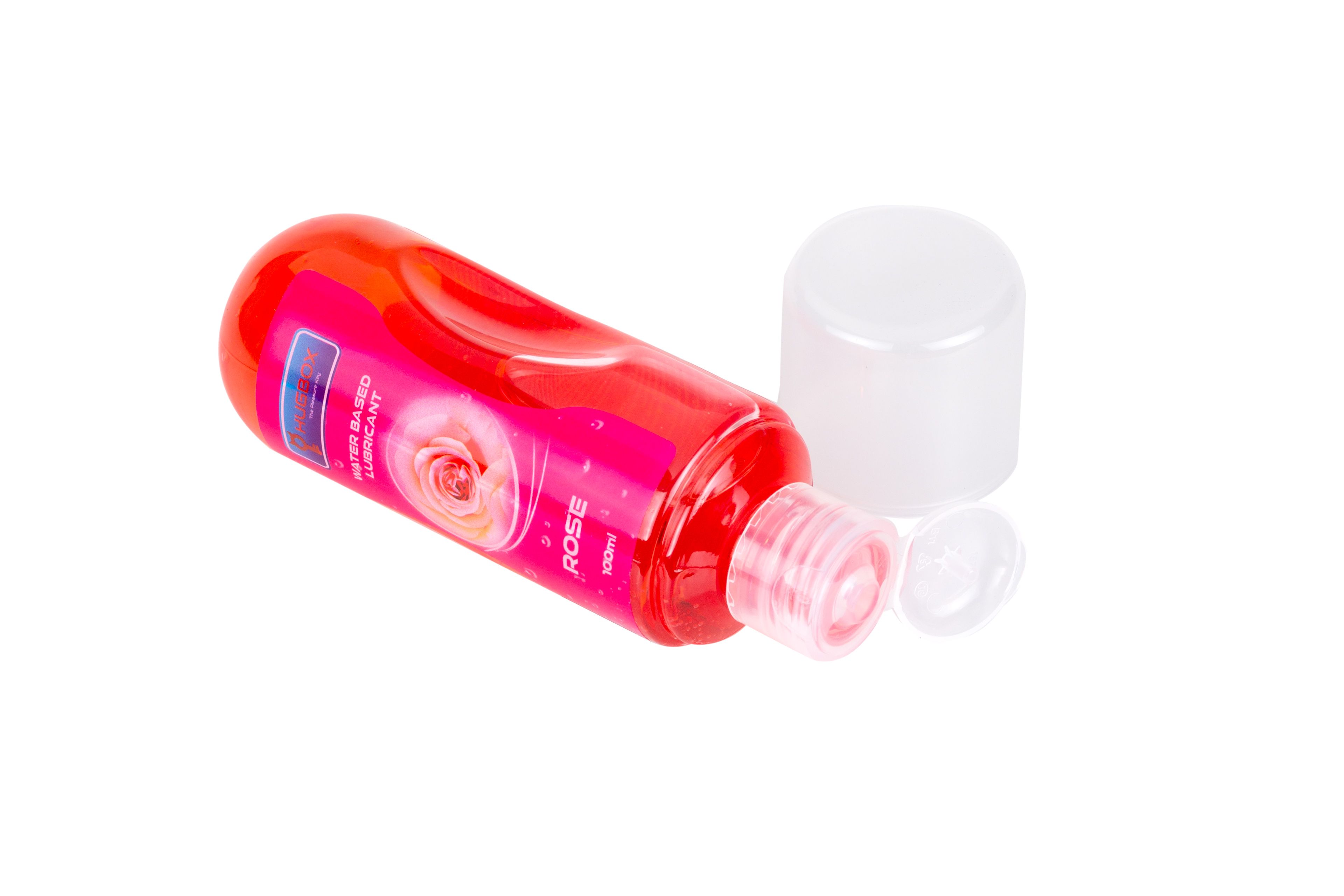 Rote Flasche mit rosa Flüssigkeit, liegend. Deckel daneben. Etikett mit Text und Rose. Produktname nicht sichtbar.