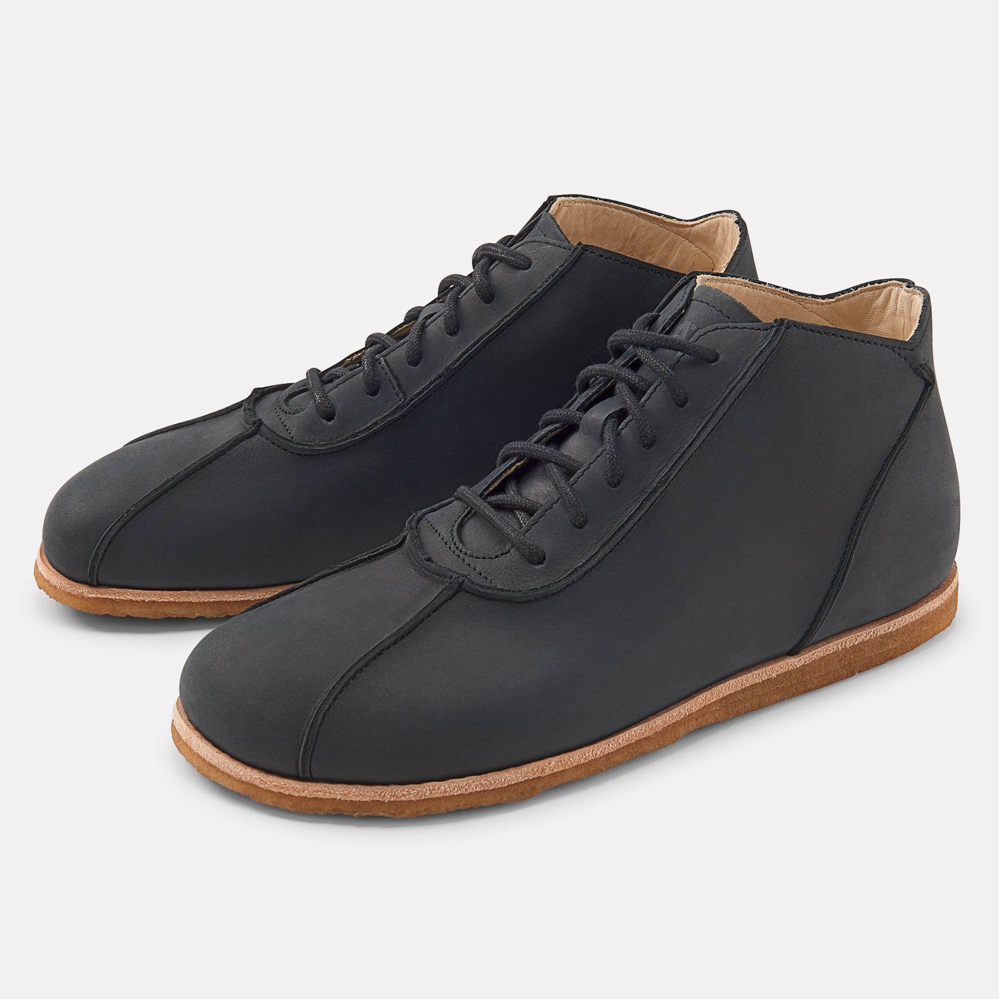 Schwarze Stiefeletten mit Schnürung und heller Sohle. Zwei Schuhe nebeneinander, leicht schräg gestellt.