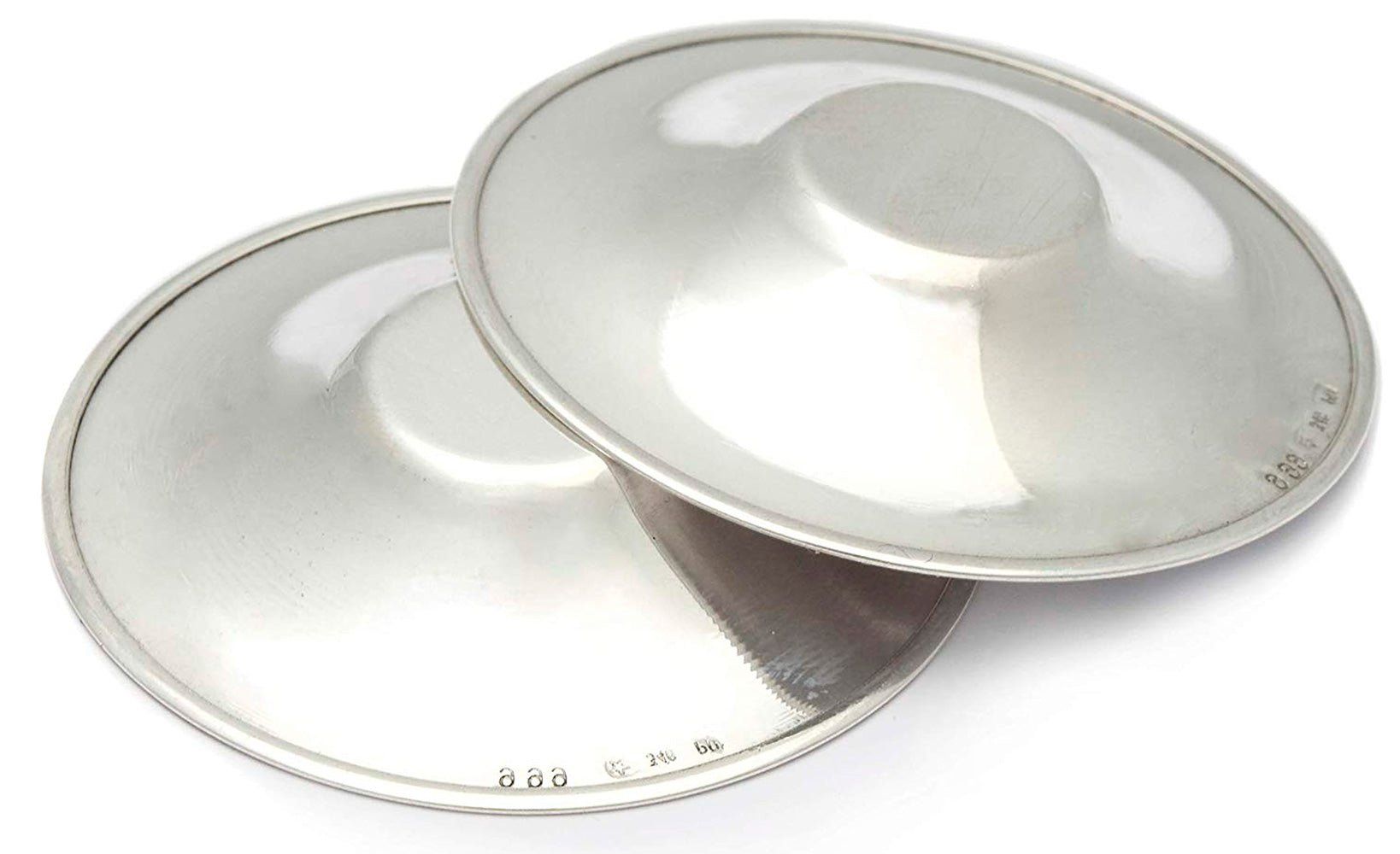 Zwei silberfarbene Brustwarzenschützer. Runde Form mit erhabenem Mittelteil. Sichtbare Prägung.