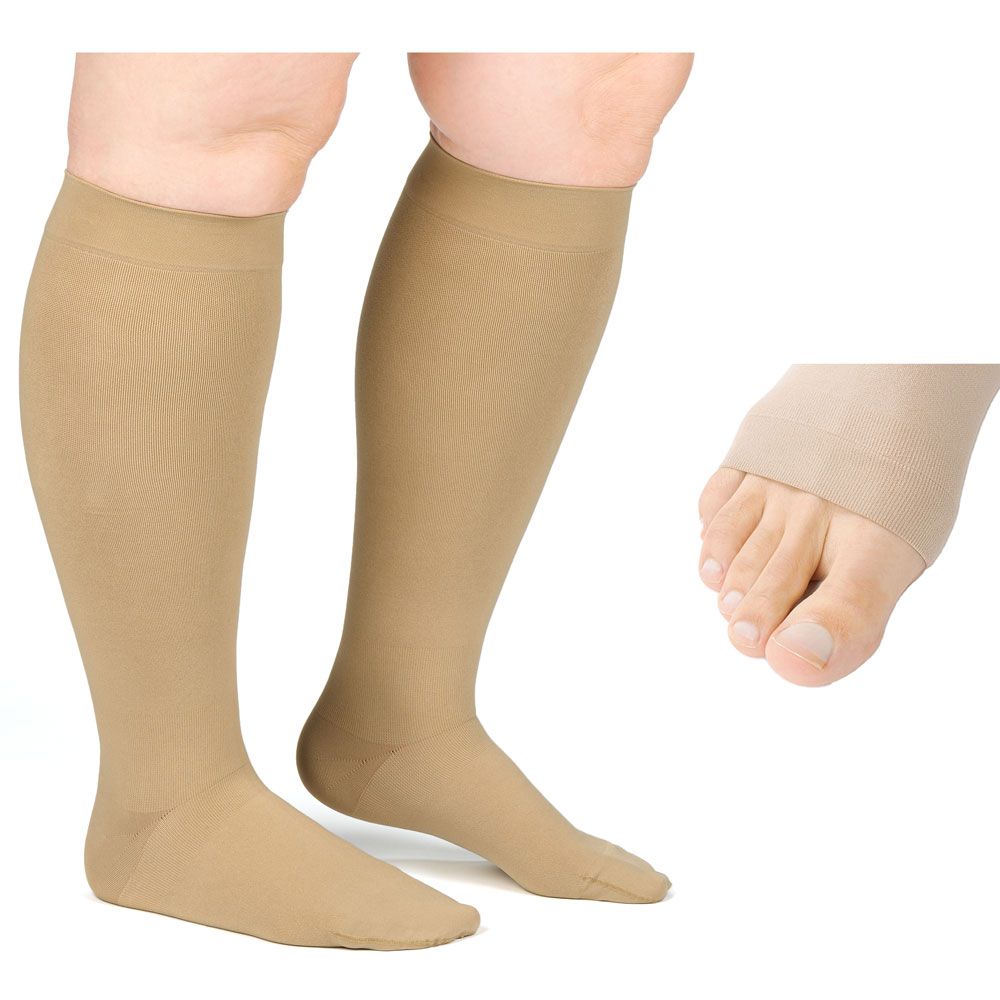 Beige Kompressionsstrümpfe am Bein. Zehenfreies Detail. Strümpfe reichen bis zum Knie. Nahaufnahme eines Fußes mit Strumpf.