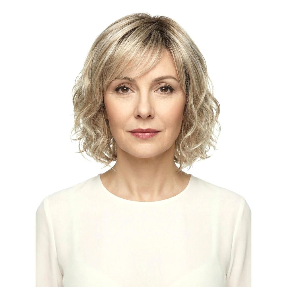 Perücke Capri von DELUXE. Blond gewellt, mit Pony. Frau mit Perücke, Frontansicht.