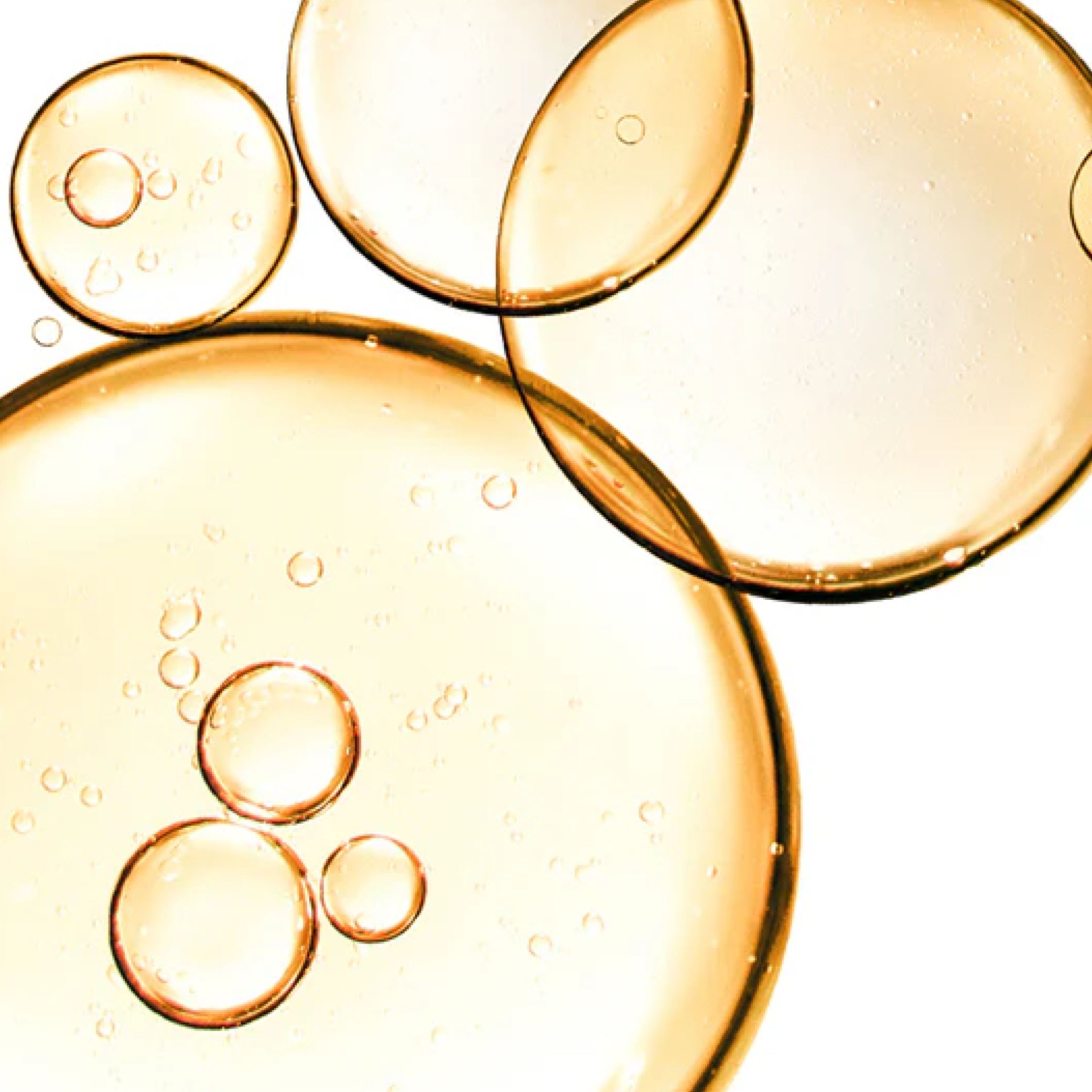 Nahaufnahme von transparenten, gelblichen Blasen. Unterschiedliche Größen und Formen, überlappend.