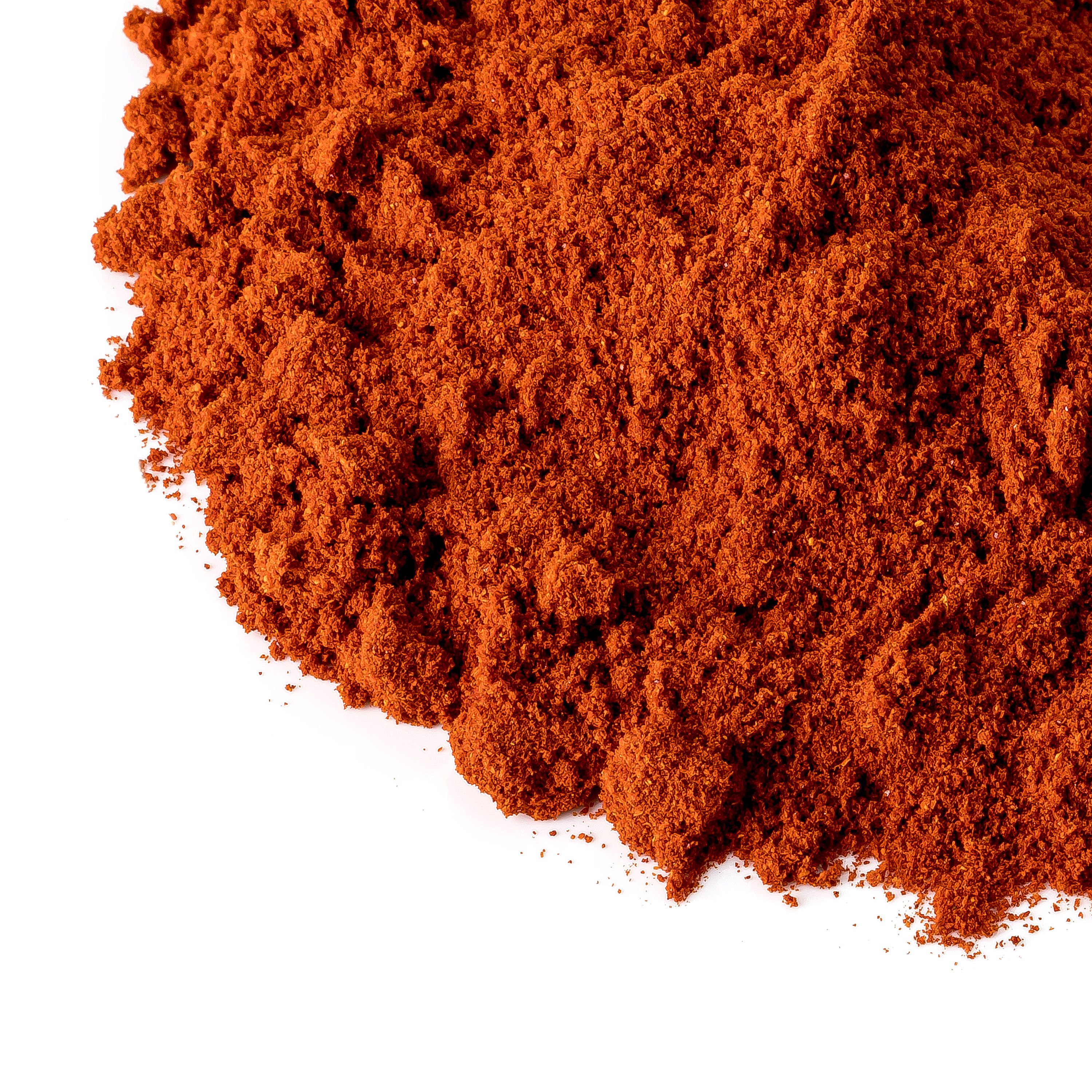 Nahaufnahme von Paprika delikatess. Orangefarbenes Pulver, unscharf am Rand. Weißer Hintergrund.