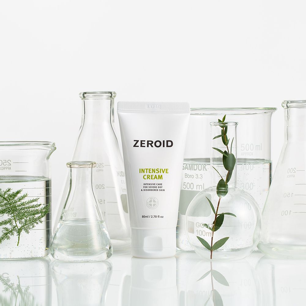 Weiße Tube vor Laborutensilien. Aufschrift: ZEROID, INTENSIVE CREAM. Text: Intensive Care for severe dry & disordered skin. 60ml/2.70 fl oz. Mit Pflanzen.