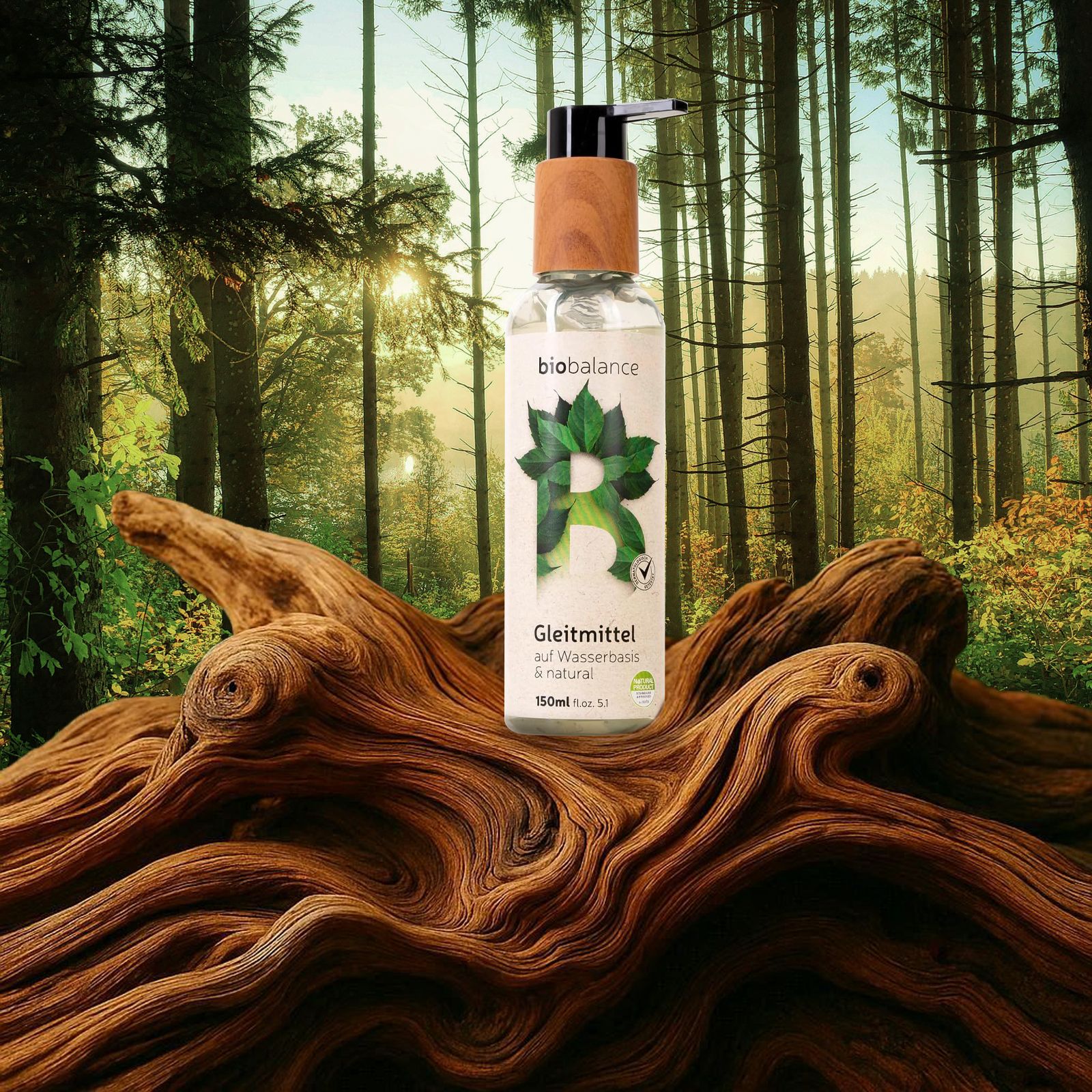 BIO BALANCE Gleitmittel-Flasche mit Holzdeckel in Waldlandschaft. Auf Baumstamm platziert.