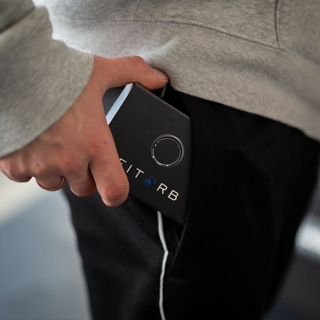 Hand in Hosentasche mit schwarzer Box. Auf der Box steht FITORB.
