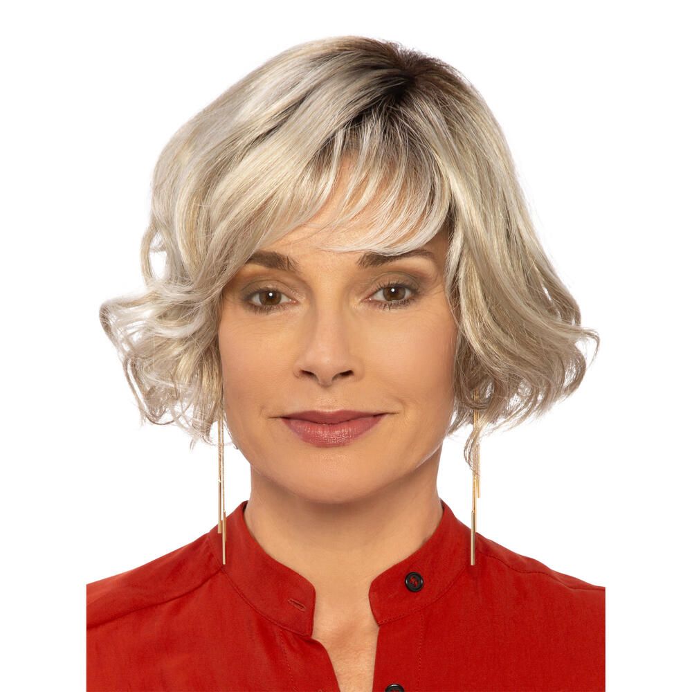 Perücke Biarritz von DELUXE. Blond gewellt, mit Pony. Frau mit roter Bluse. Frontansicht.