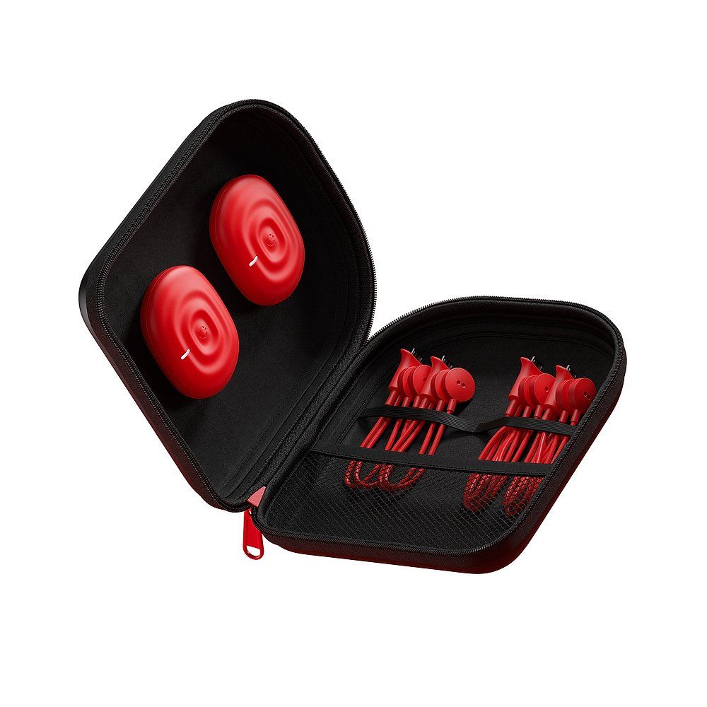 Schwarze Tragetasche mit rotem Reißverschluss. Enthält zwei runde, rote Geräte und rote Kabel.