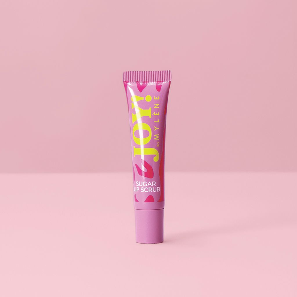 Mylène JOY! Sugar Lip Scrub in rosa Tube auf rosa Hintergrund.