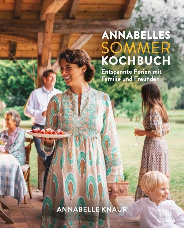 Buchcover: "Annabelles Sommer Kochbuch". Frau mit Essen, Familie im Hintergrund. Titel in Gelb und Weiß, Autorin Annabelle Knau.