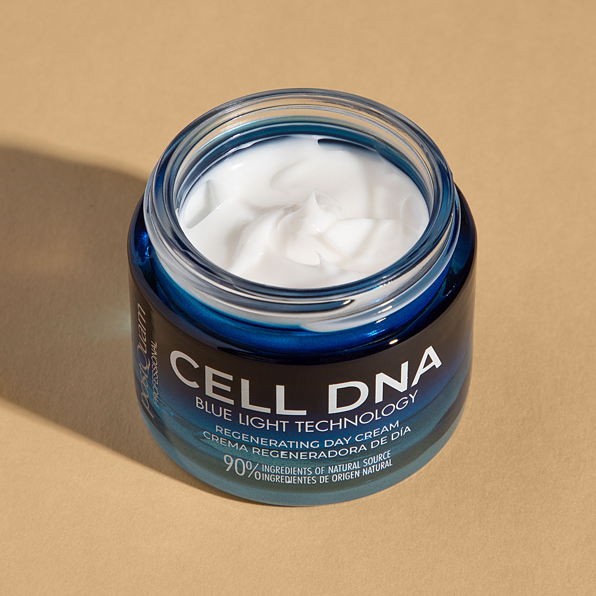 Geöffnete Postquam Cell DNA Tagescreme. Blaue Glasdose mit weißer Creme. Aufschrift: CELL DNA, Blue Light Technology, Regenerating Day Cream.