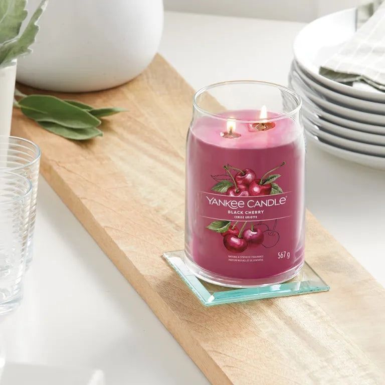 Duftkerze auf Holzbrett. Kirsch-Dekor und Schriftzug. Zwei Dochte. Auf Glasuntersetzer.