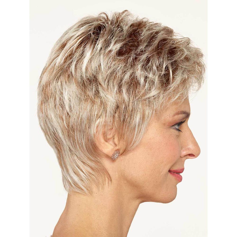 Kurzhaarperücke in Blondtönen. Seitenansicht. Frau mit Perücke. Ohrringe. Rosa Oberteil. Heller Hintergrund.