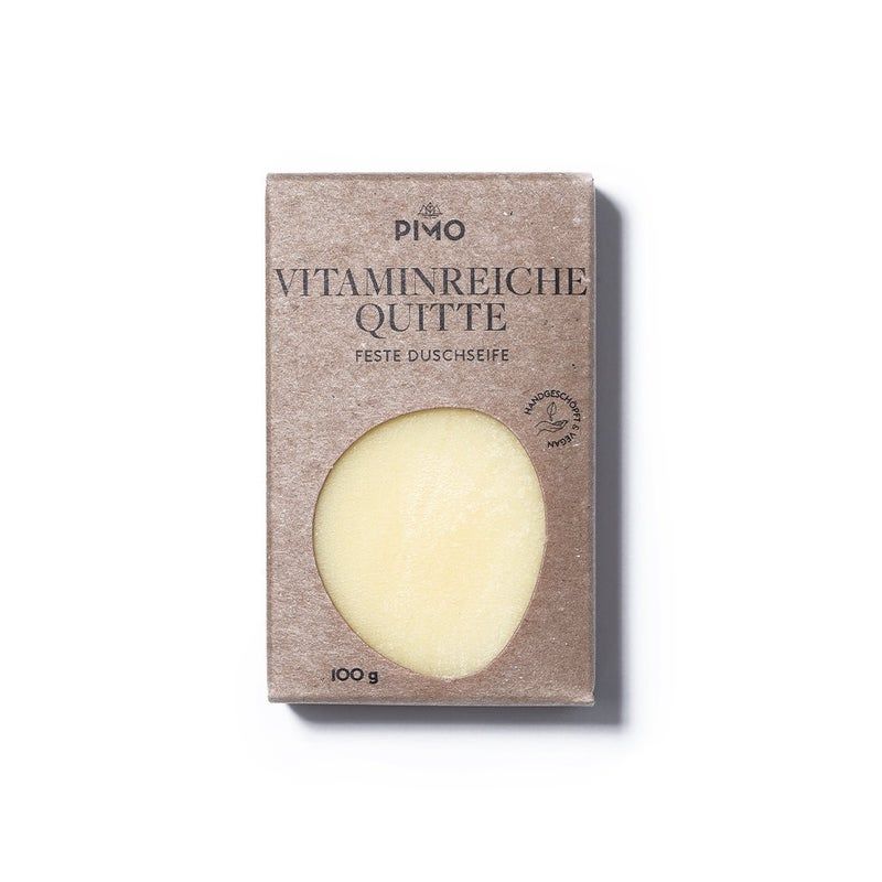 PIMO Duschseife Vitaminreiche Quitte. Die rechteckige Verpackung aus braunem Karton zeigt einen Ausschnitt, der die ovale Seife freilegt. Auf der Verpackung stehen die Worte "Vitaminreiche Quitte" und "Feste Duschseife". Das Produkt ist handgefertigt und wiegt 100g.