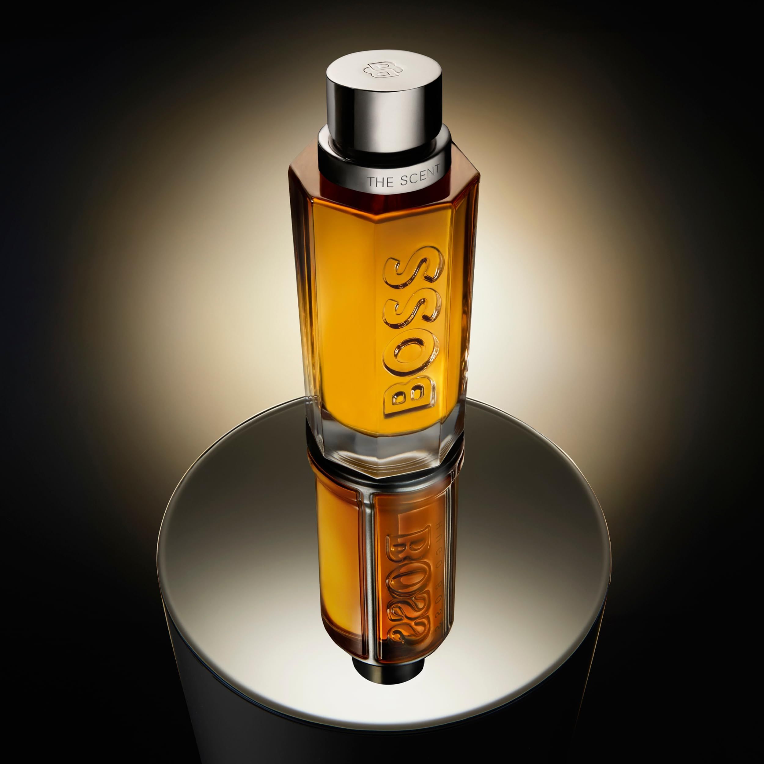 Hugo Boss The Scent Eau de Parfum Flakon auf spiegelnder Oberfläche, reflektiert.