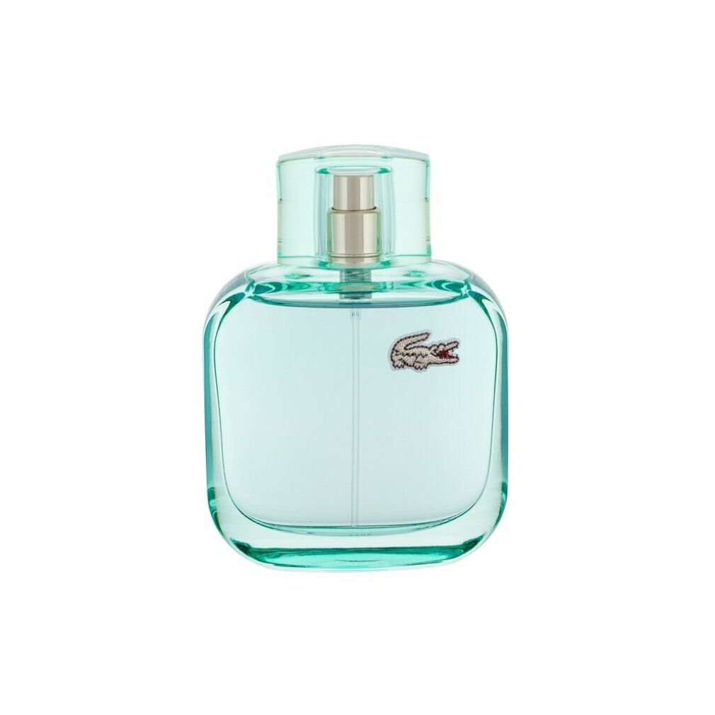Hellblaue Flasche mit Sprühkopf. Lacoste-Logo auf der Vorderseite. Transparente Flüssigkeit sichtbar.