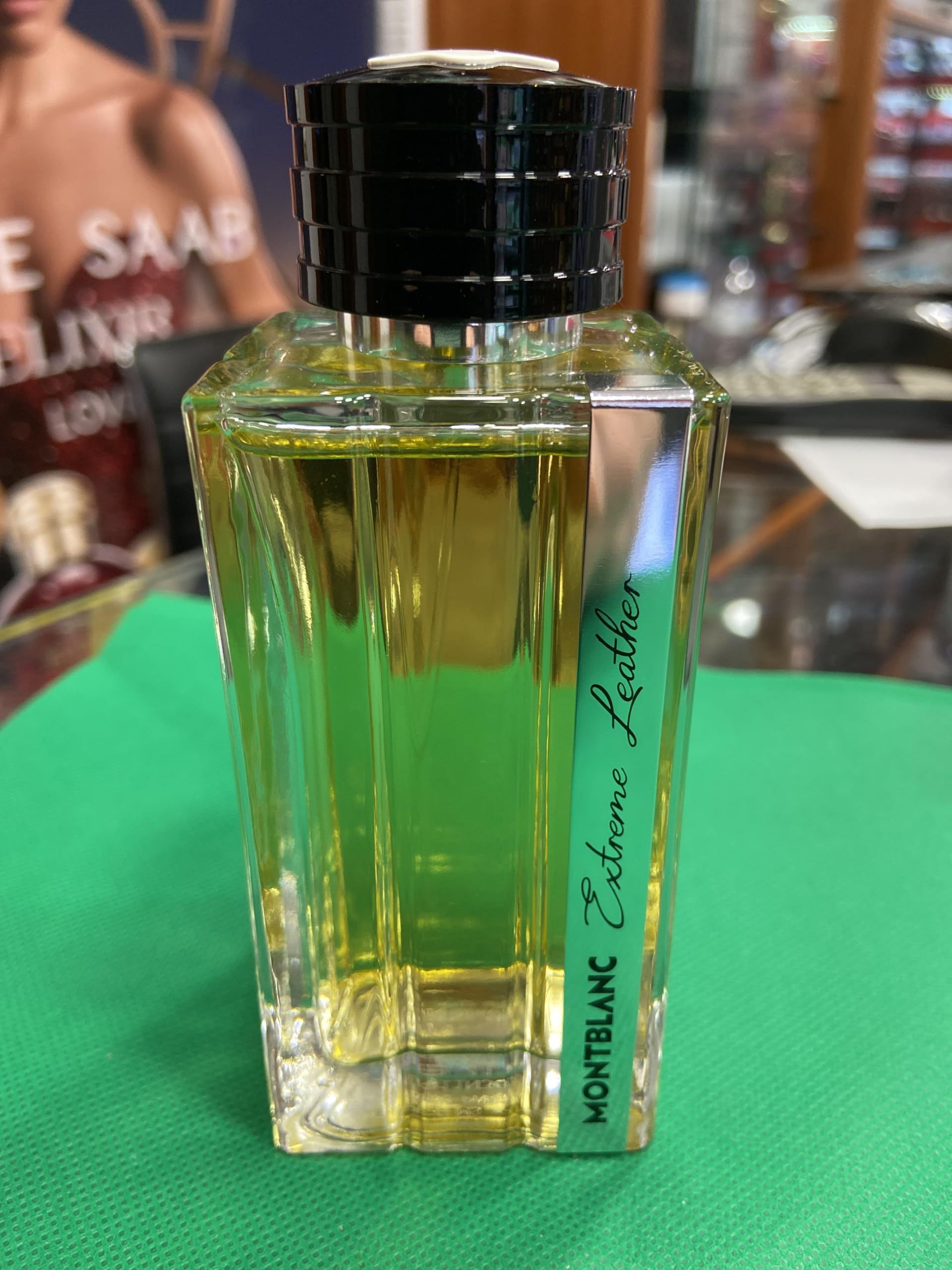 Glasflakon mit schwarzem Verschluss. Aufschrift: Montblanc Extreme Leather. Grüne Flüssigkeit sichtbar.