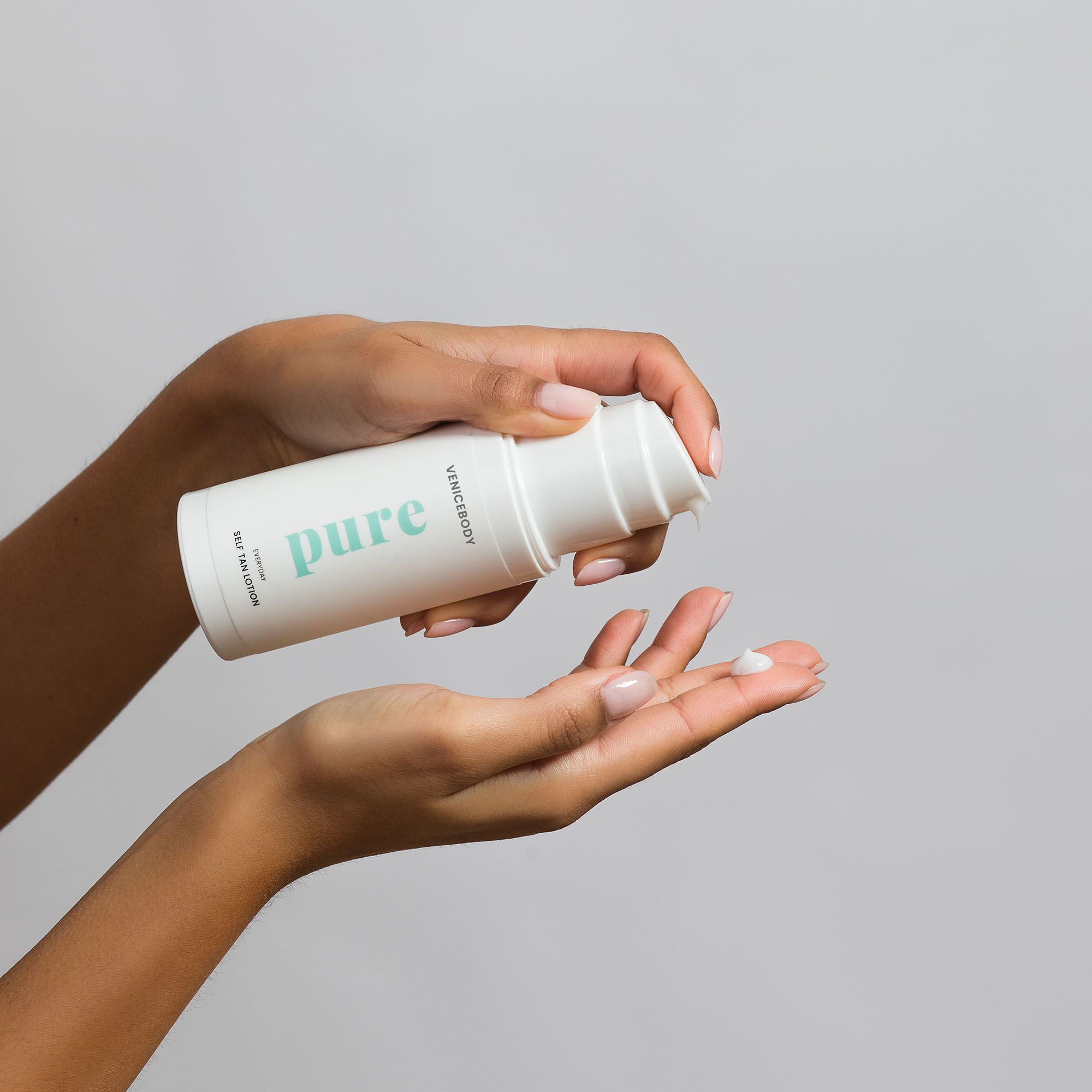 Weiße Flasche VENICEBODY pure Everyday Self Tan Lotion, Produkt wird auf die Hand aufgetragen.