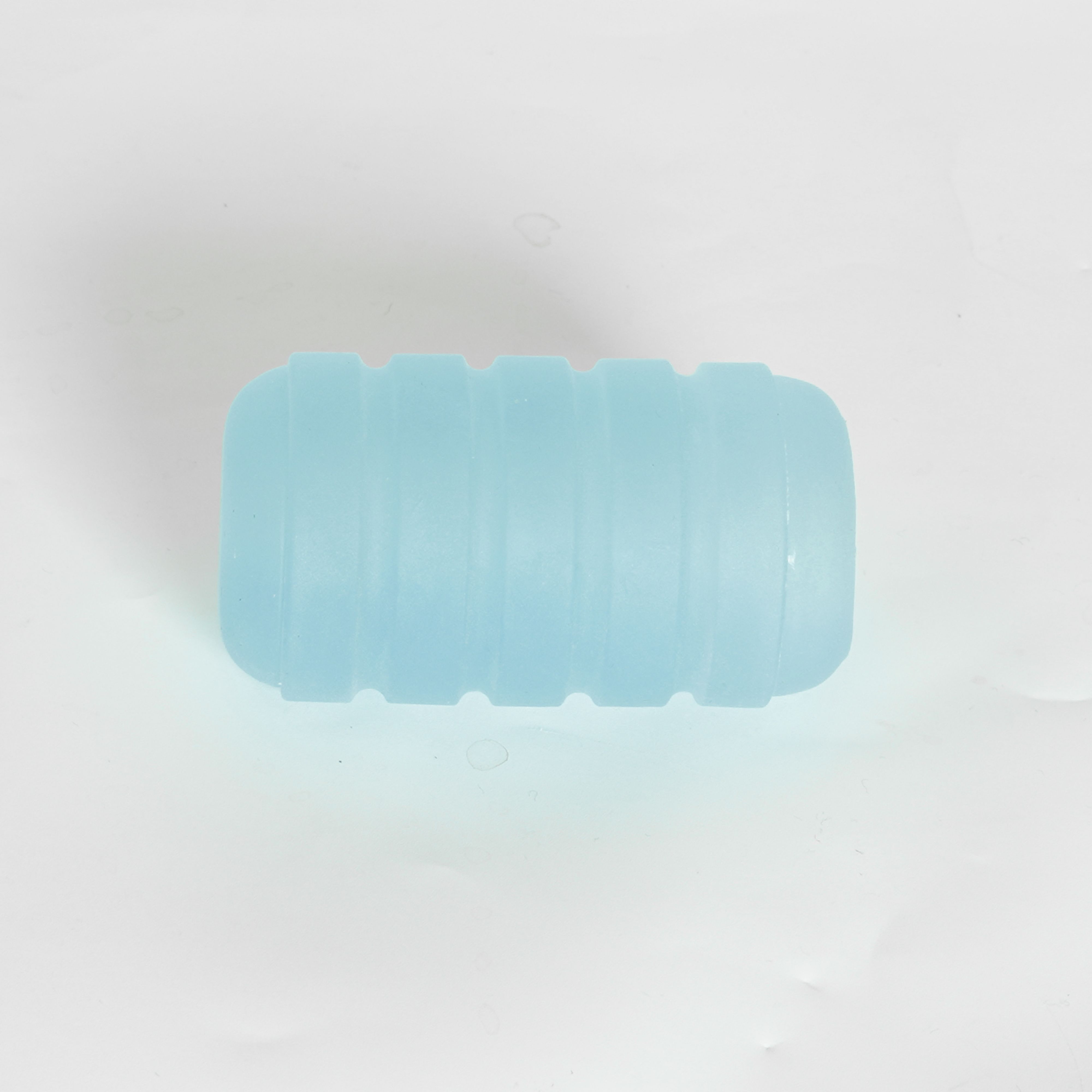 Rechteckiges, blaues Silikonprodukt mit geriffelter Oberfläche. Auf weißem Hintergrund.