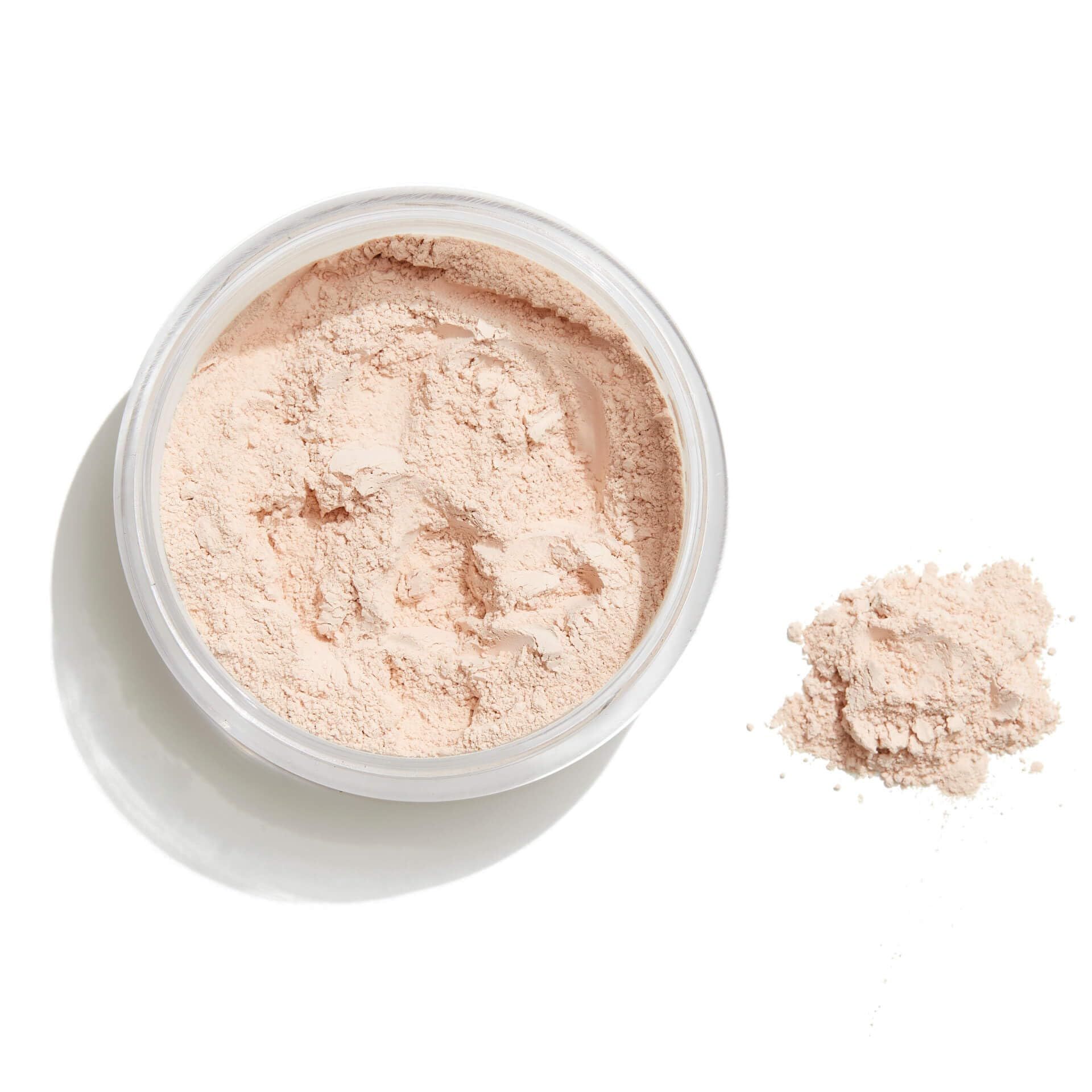 Offene Dose mit Puder und Puderhaufen daneben. Transparenter Behälter. Weißer Hintergrund.