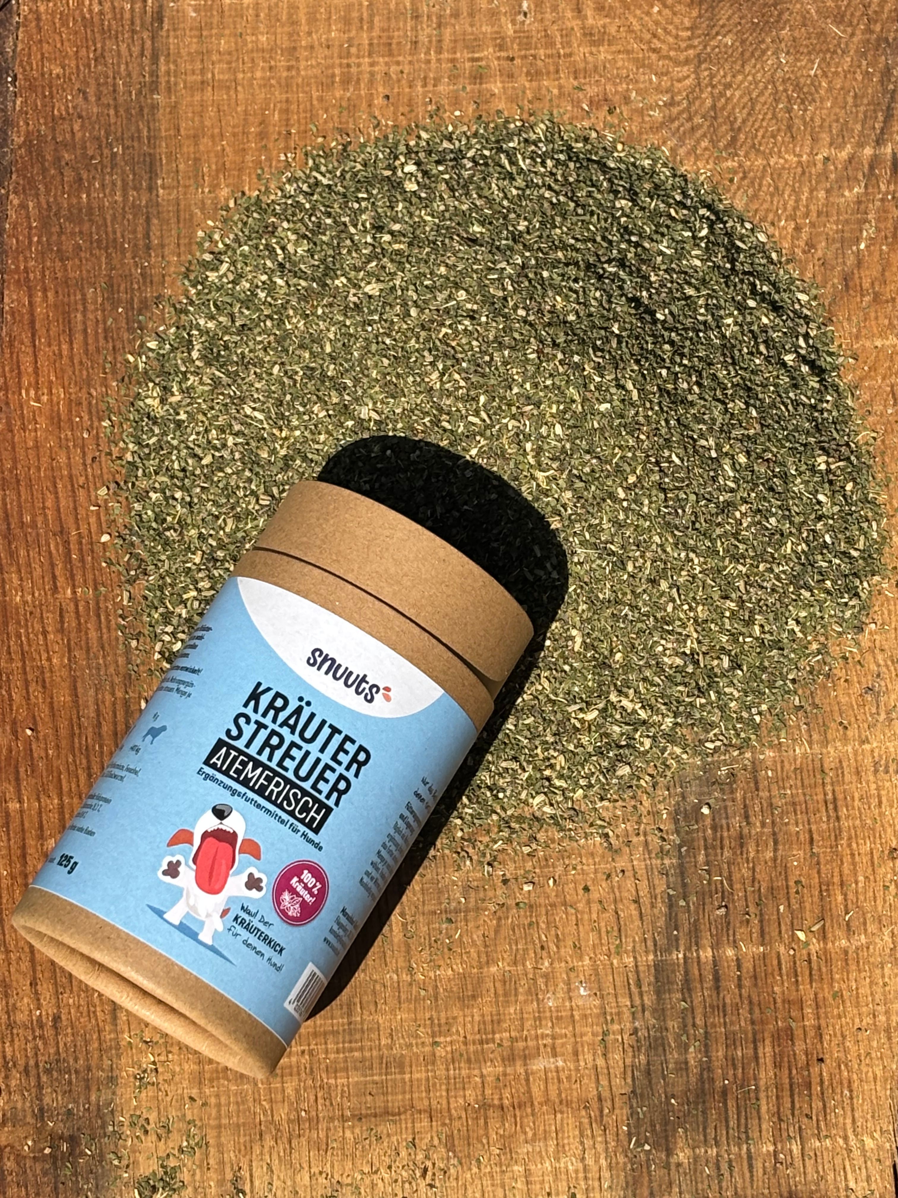 Zylindrische Verpackung und Kräuterstreuer. Aufschrift: snuuts Kräuterstreuer Atemfrisch. Kräuter auf Holzuntergrund verstreut.