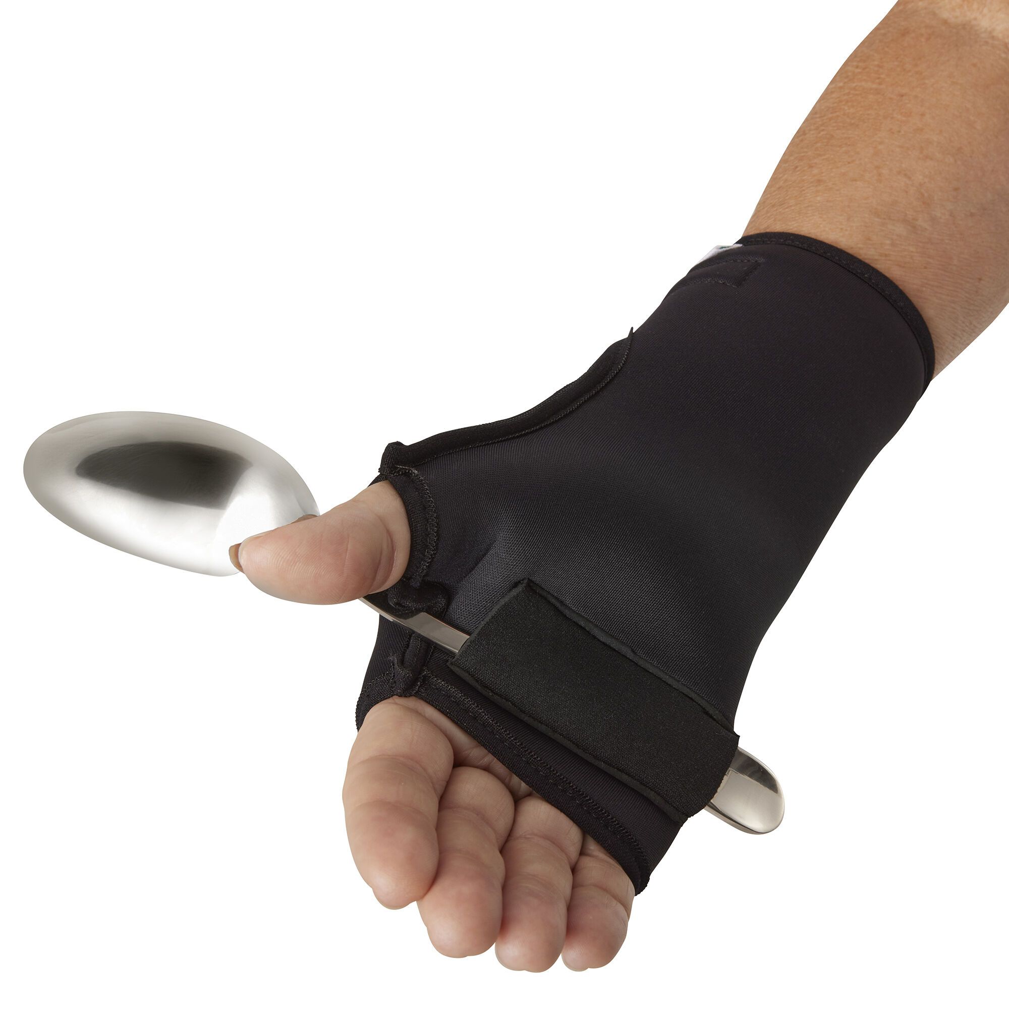 Schwarzer Handgelenk- und Daumenhalter mit Klettverschluss. Ein Löffel wird gehalten. Der Halter umschließt die Hand.