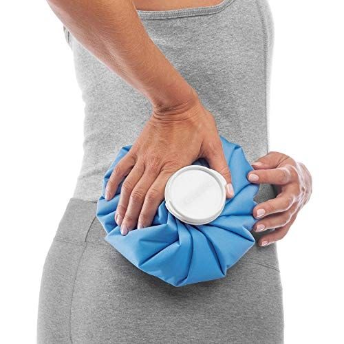 Blauwe ijszak, vastgehouden door persoon op rug. Witte sluiting. Persoon draagt sportkleding.